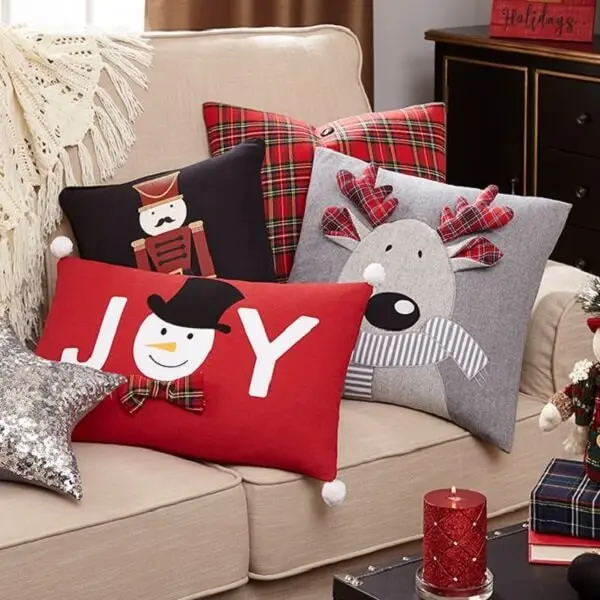 4 almofadas de natal decorando um sofa na sala 