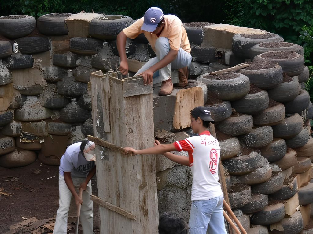 homens construindo uma casa ecológica com pneus velhos