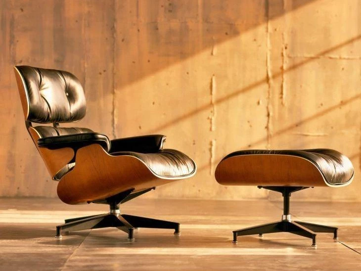 modelo de uma poltrona com puff para pés de couro modelo charles eames de couro com madeira, pés de metal estilo giratório
