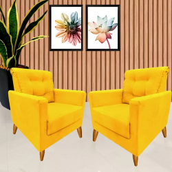 sala de estar com duas poltronas decorativas na cor amarela, ao fundo dois quadros pendurados com imagens de flor, e ao lado uma vaso com planta espada de são jorge