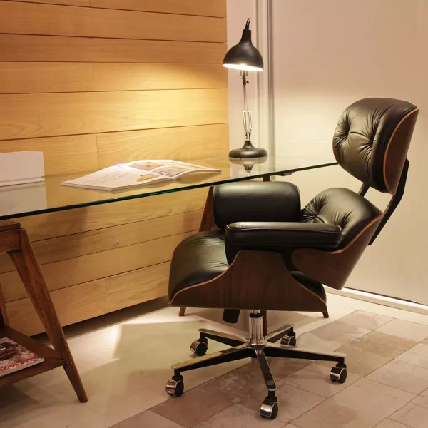 escritório com mesa de vidro e uma cadeira charles eames de couro estilo giratória.