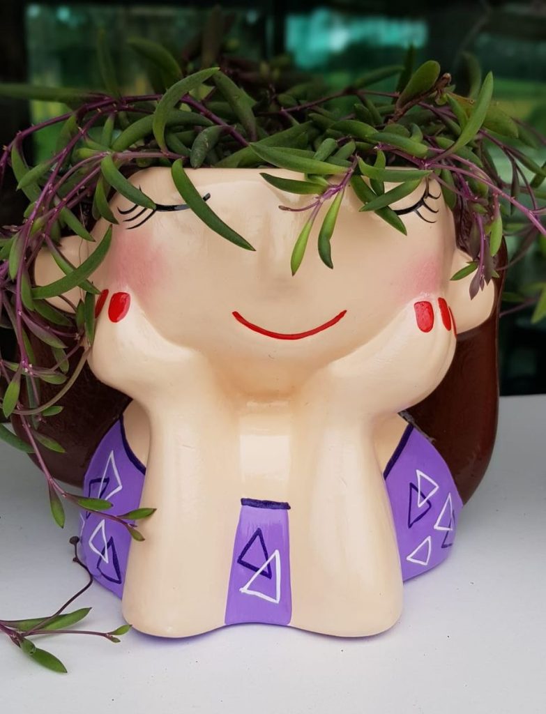 vaso em formato demenina com cabelo de plantas estilo cachepo
