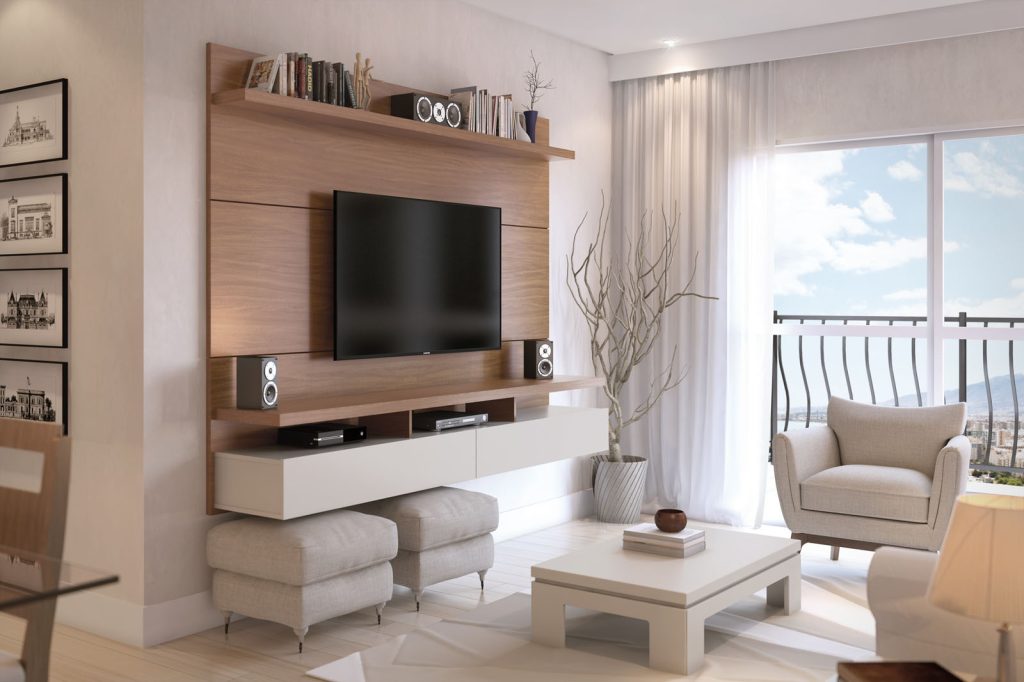 sala com sacada visível, decoração de sofa, rack e painel nos tons branco e amadeirado.