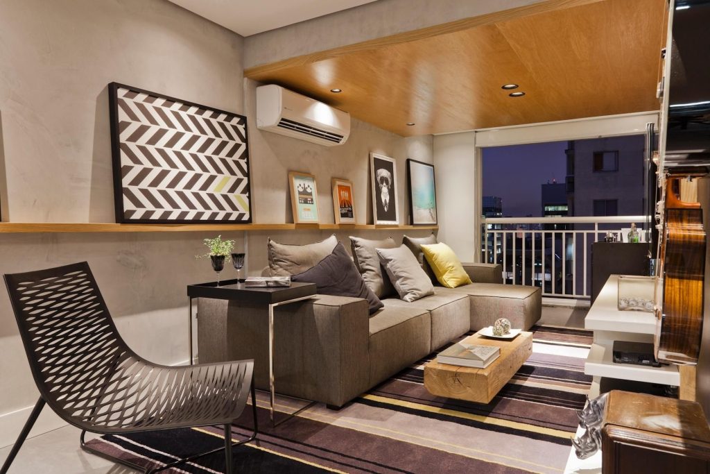 sala em apartamento com sofa grande na cor bege uma cadeira ao ao com decoração sofisticada
