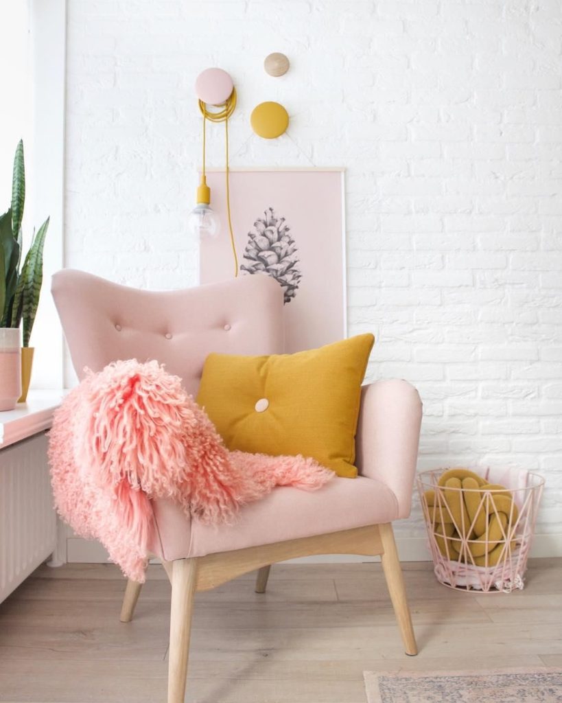 poltrona com pelego na cor rosa em um ambiente de sala 