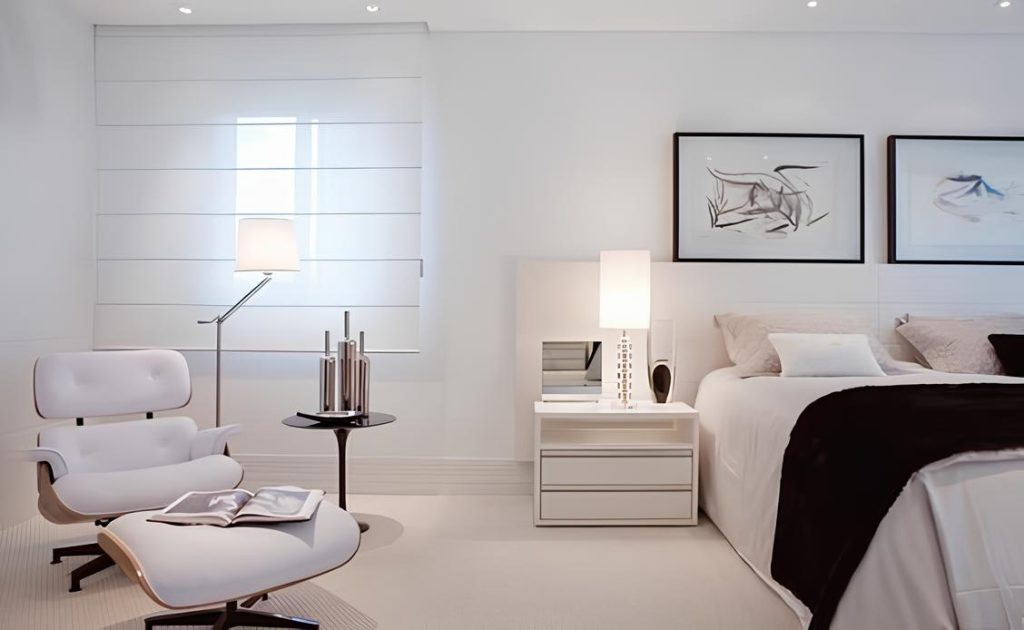 quarto de casal moderno nas cores branco com detalhes preto, uma poltrona charles eames branca