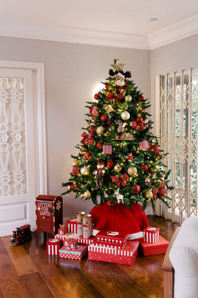 arvore de natal decorada no canto de uma sala de estar com presentes