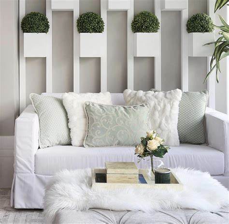 sala de estar com tons claros e sofa grande na cor branca 