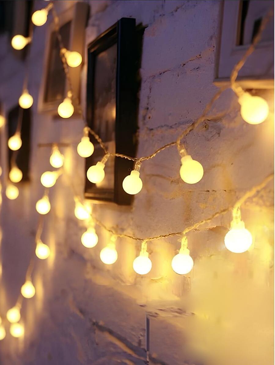 modelo de luminária com lâmpada bulbo em uma parede com alguns quadros decorativos.