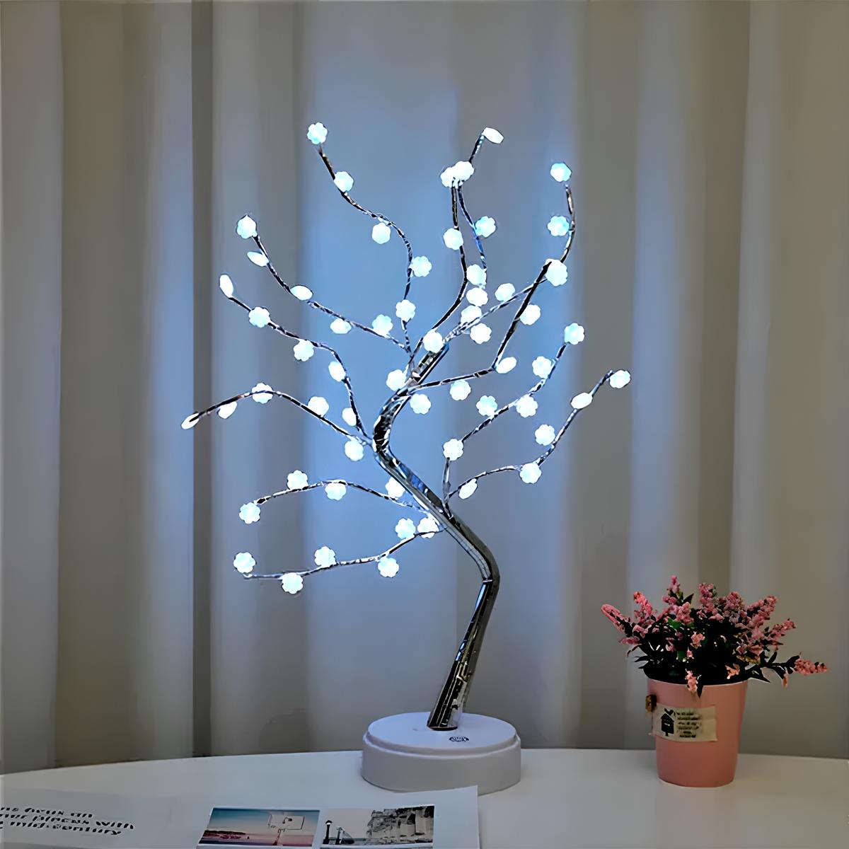 mesa com uma luminária em estilo árvore em cima dela, ao lado um vasinho de flores pequeno na cor rosa.