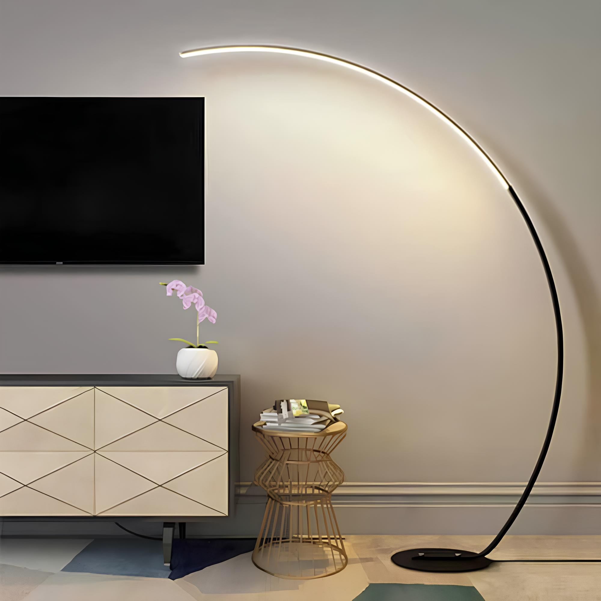 espaço com um armário moderno, uma mesinha de metal na cor dourada e ao lado uma luminária de LED moderna, na parede uma TV .