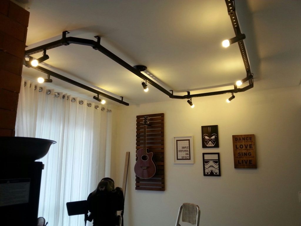 modelo de um quarto com objetos decorativos, quadros decorativos e uma luminárias de teto em estilo eletrocalhas.