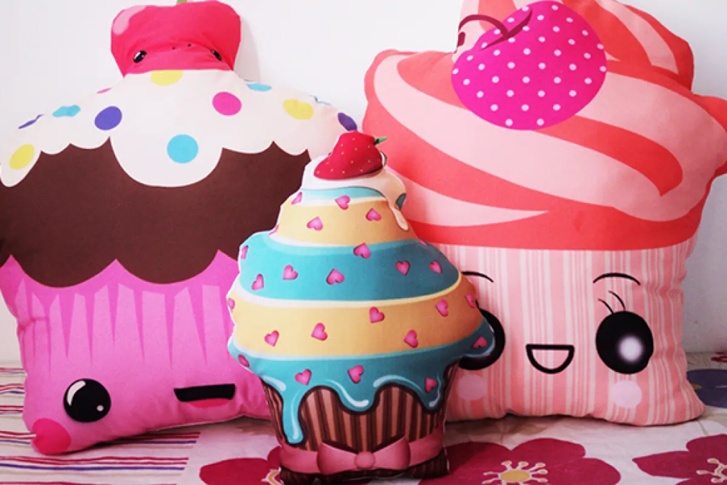 três modelos de almofadas infantis em formatos de cupcake