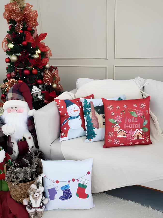 sala de estar com sofá branco, uma manta branca e almofadas de natal, ao lado um papai Noel de boneco e atrás dele uma árvore natalina com enfeites, no chão outra almofada e cesto com enfeites de natal.