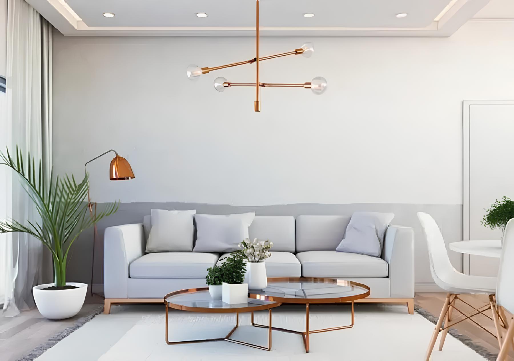 sala de estar ampla com sofá na cor branca encostado em uma parede, em frente a ele uma mesinha de centro de vidro com vasinhos de plantas em cima dela, no chão um tapete grande claro, ao lado do sofá uma luminária e um vaso grande com planta. no teto uma luminária moderna .