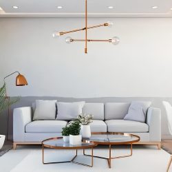 sala de estar ampla com sofá na cor cinza com almofadas em cima das mesas cores e tecidos, ao meio duas mesinhas de centro redonda com vasinhos de plantas em cima dela, ao lado do sofá vaso de planta grande, em cima no teto uma luminária moderna.