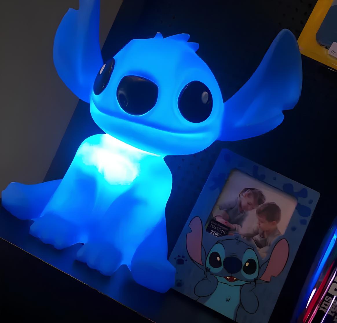 uma luminária em formato do personagem lilo stit e ao lado dele um porta retrato com o lilo.