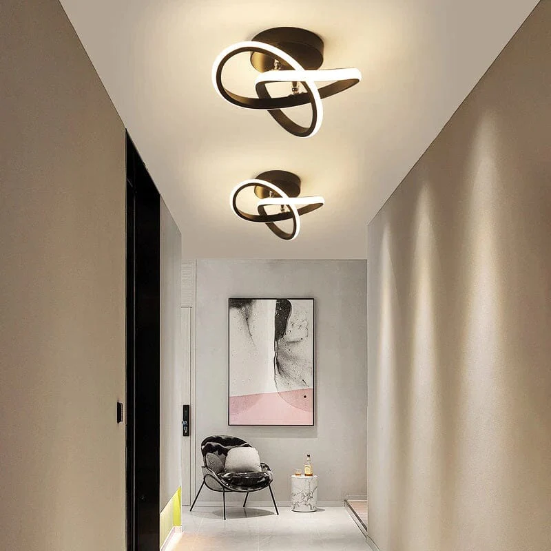 corredor com uma cadeira e um quadro grande na parede, no teto duas luminárias de plafons.