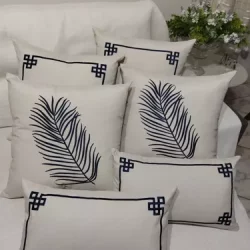 modelos de cinco almofadas com bordados em formas de desenhos nas cores azuis.