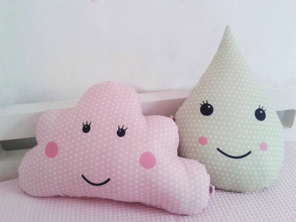 dois modelos de almofadas em formato de nuvem e gota de agua sorridente nas cores rosa e verde claro.