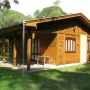 uma casa de madeira pequena 6x7 com varanda, em volta dela gramado