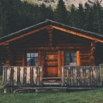 casa de madeira com troncos de árvores em estilo rústico com varanda.