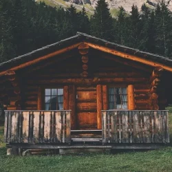 casa de madeira com troncos de árvores em estilo rústico com varanda.
