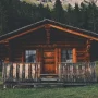 casa de madeira com troncos de árvores em estilo rústico com varanda.