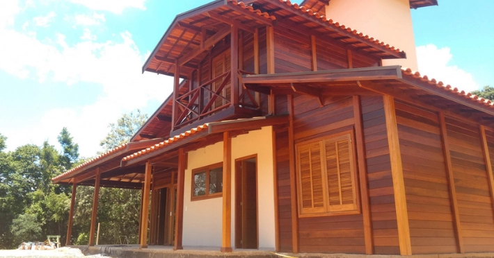 uma casa de madeira de dois andares feita com madeiras maciças