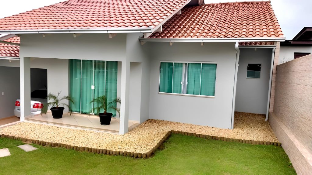 uma casa de alvenaria simples com gramado, garagem e varanda.
